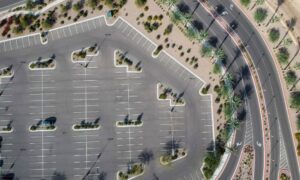 A drone surveying image showing a city parking lot beside a landscaped green area, highlighting the contrast between asphalt and vegetation.