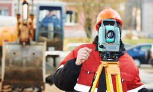 Licensed surveyor adjusting total station on site - ALTA SURVEY Nashville A licensed surveyor adjusts a total station during fieldwork as new rules may soon affect how property surveys are completed