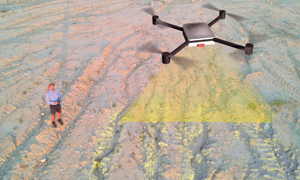 Drone technician using Lidar mapping to scan ground features during a land survey