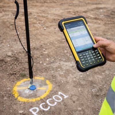 Gnss control point field measurement - ALTA SURVEY Nashville Commercial property surveyor verifying a GNSS control point with a field data collector on a construction site