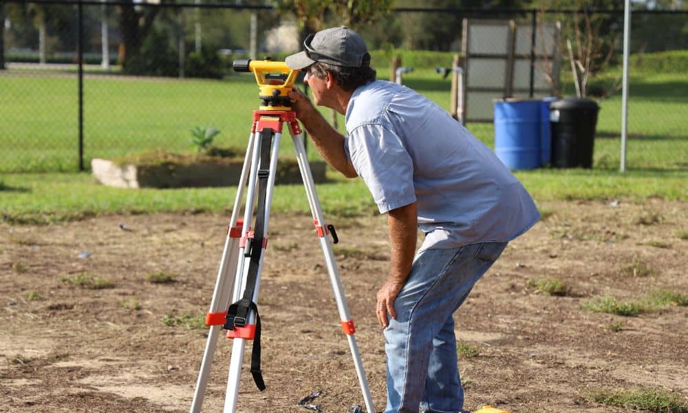 Property boundary measurement tripod yard - ALTA SURVEY Nashville Residential surveyor measuring a yard boundary with tripod survey equipment during a property survey