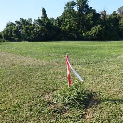 Property corner flag boundary marker field - ALTA SURVEY Nashville Boundary corner marker with survey flag placed by a residential surveyor to identify a property line