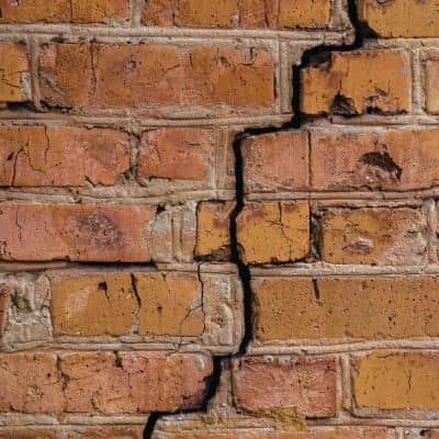 Stair step brick wall structural crack - ALTA SURVEY Nashville Construction engineer reviewing stair-step brick wall cracks that indicate structural movement