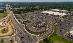 Aerial view of a developing commercial site showing building layout, road access points, and traffic movement highlighting how site development decisions affect real-world use