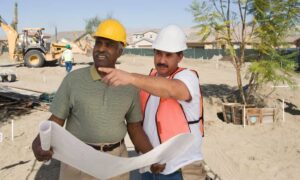Site engineer reviewing plans on an early-stage construction site before work begins