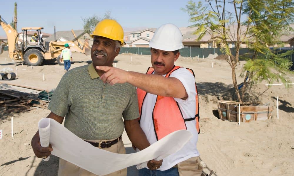 Site engineer reviewing plans on an early-stage construction site before work begins